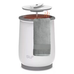 A white towel warmer with a gray towel hanging from it, featuring a lid that lifts to release heat.