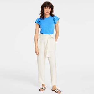 Bright blue crew-neck t-shirt with ruffle sleeves paired with high-waisted, cream-colored belted trousers and open-toed slide sandals.