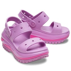 Lavender-colored Crocs Classic Mega Crush Sandals feature thick platform soles in pink, adjustable straps, and breathable perforations, combining style and comfort.