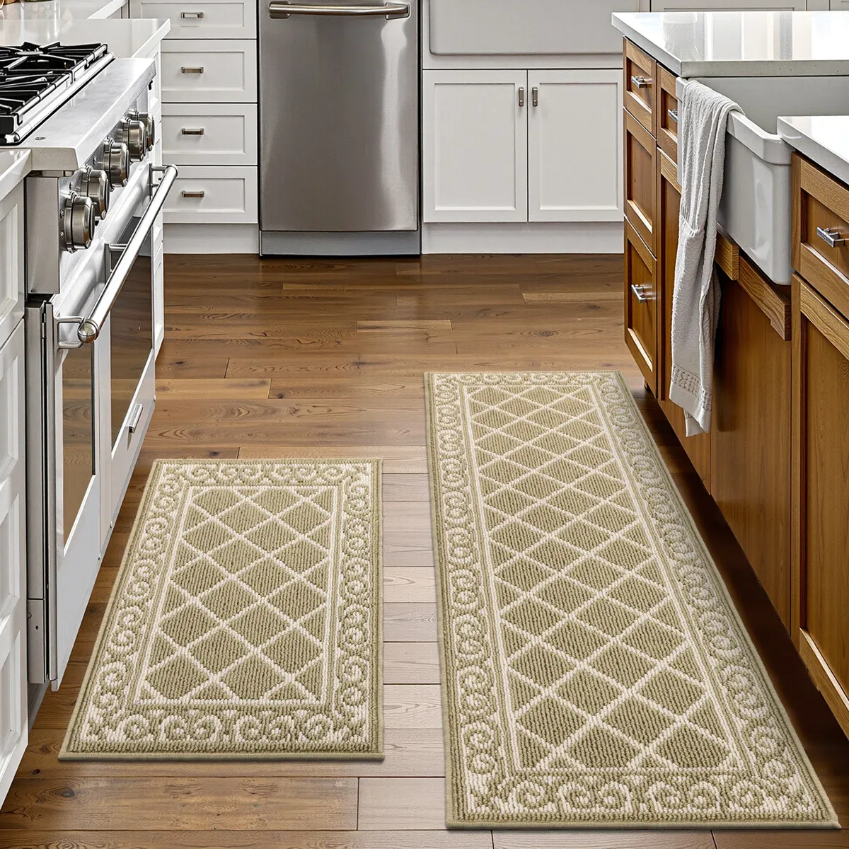 Two beige kitchen rugs with decorative patterns are placed on a wooden floor, one in front of a stove and the other beside a kitchen island with a sink.
