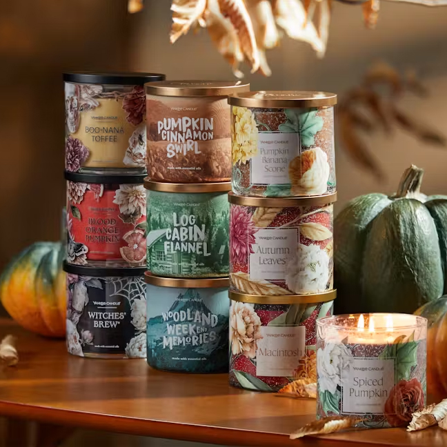 A stack of candles includes the Yankee Candle Boo-Nana Toffee 14.5oz, which is a candle with a black label featuring illustrations of bananas, leaves, and toffee.