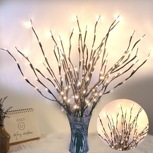 LED light branches in a vase create an illuminated decorative display, ideal for festive or ambient home decor. A small calendar nearby displays a festive greeting and a smiley face.