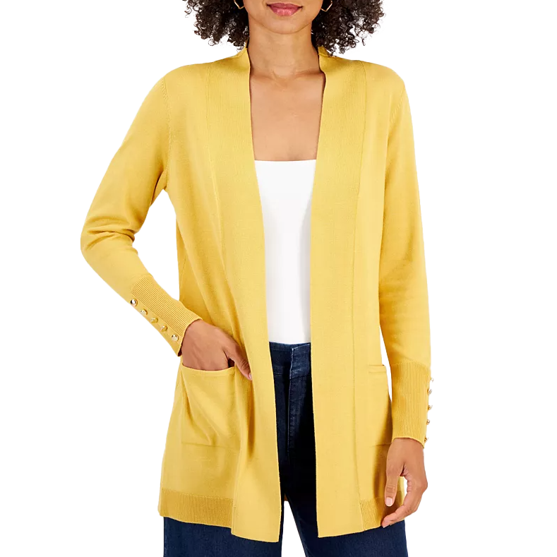 A woman wearing a yellow cardigan with ribbed cuffs and button accents, paired with a white top and dark jeans.