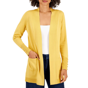 A woman wearing a yellow cardigan with ribbed cuffs and button accents, paired with a white top and dark jeans.