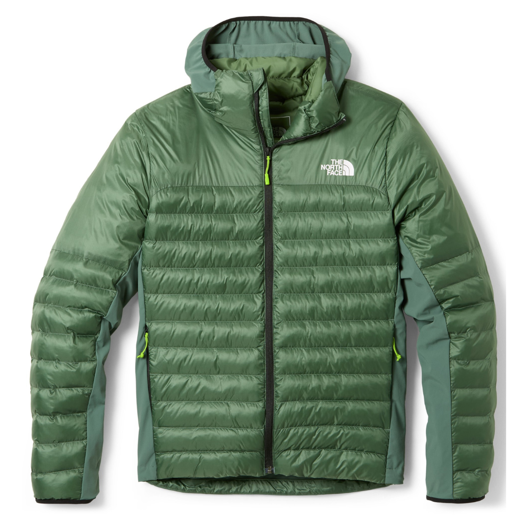 Green puffer jacket with a front zipper, zippered pockets, and a logo on the chest, featuring a quilted design for insulation.