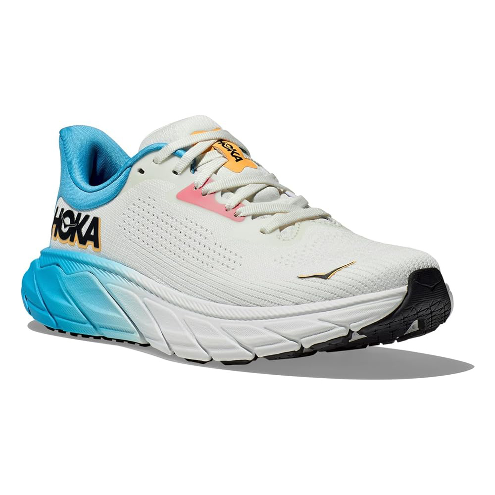 Hoka Women's Arahi 7 Running Shoes are designed with a lightweight mesh upper, stability cushioning, and a bold color design featuring white, blue, and pink accents with a visible logo. Ideal for providing support and comfort during runs.