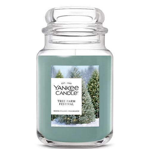 Yankee Candle \“Tree Farm Festival\“ in a large glass jar, featuring a winter-themed label with evergreen trees.