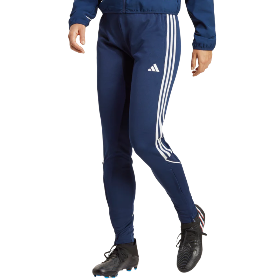 Navy blue Adidas track pants with white stripes on the sides, paired with black athletic shoes.