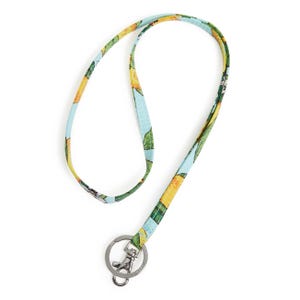 A colorful fabric lanyard with a tropical fruit design on a light blue background, featuring a silver-tone key ring and lobster clasp for holding keys or ID badges.