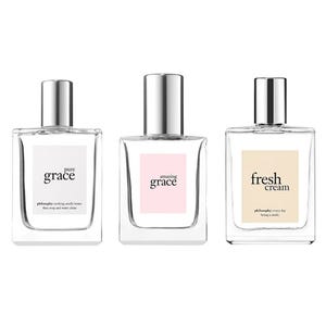 Three Philosophy fragrances in clear, rectangular glass bottles, each with a silver cap and labeled respectively: \“pure grace,\“ \“amazing grace,\“ and \“fresh cream.\“