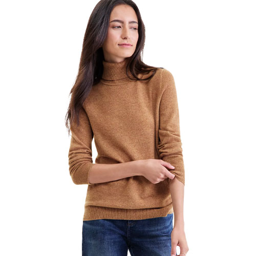 A woman is wearing a brown turtleneck sweater paired with blue jeans.