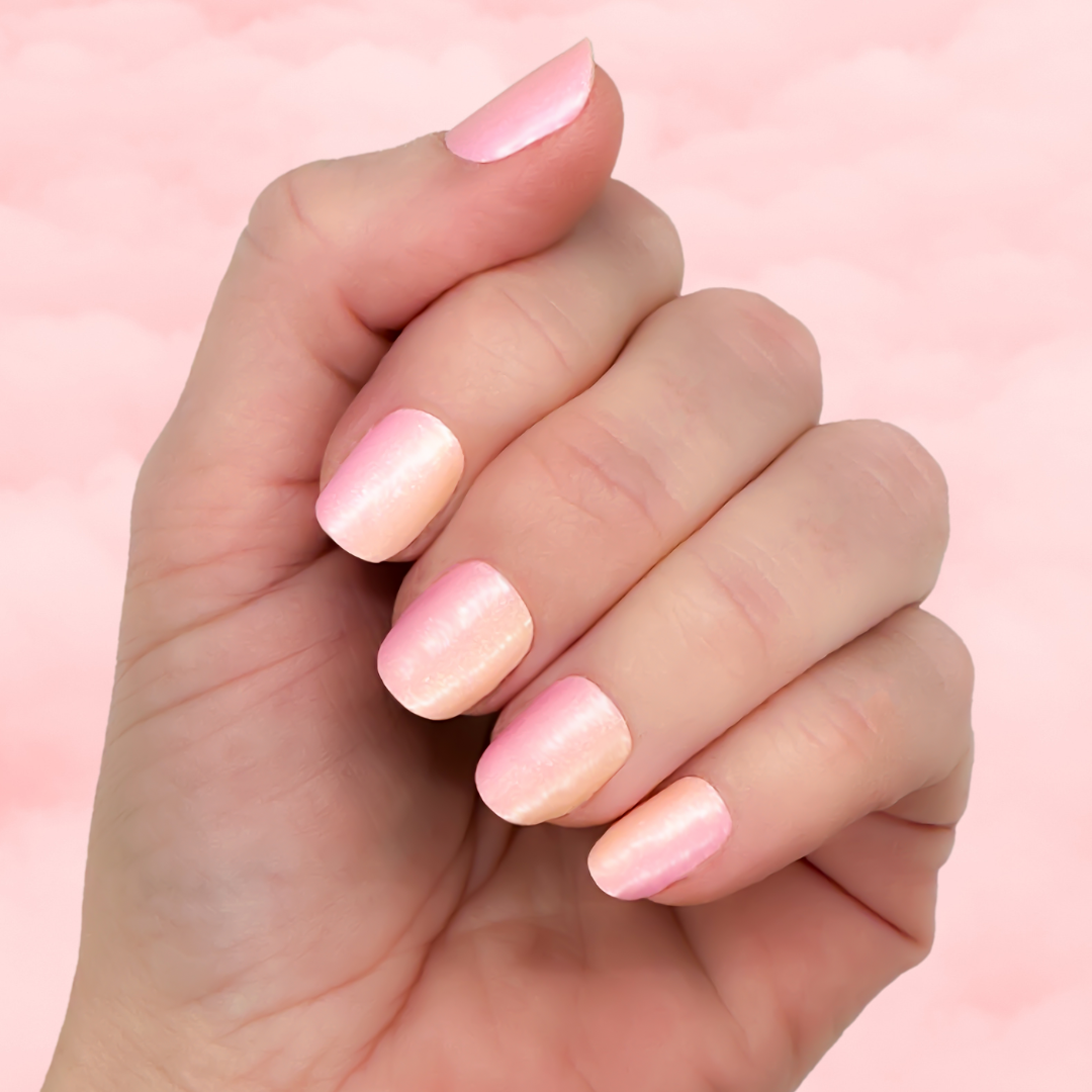 A hand with pink shimmering nail polish.