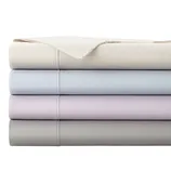 A stack of neatly folded bed sheets in four pastel colors: cream, light blue, lavender, and gray, with visible stitching details.