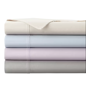 A stack of neatly folded bed sheets in four pastel colors: cream, light blue, lavender, and gray, with visible stitching details.
