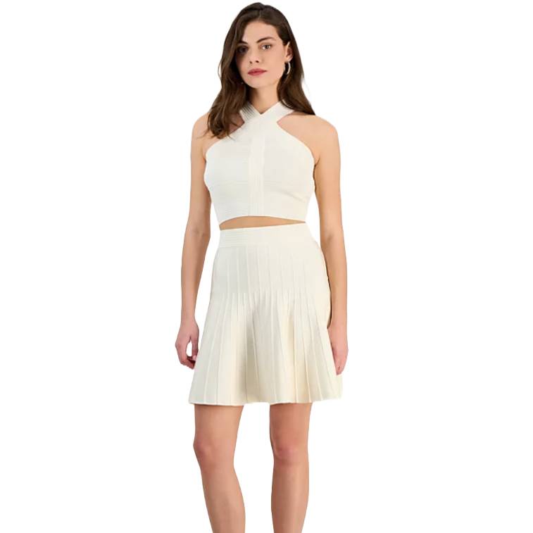A white knit skirt with a high waist and pleated A-line design, paired with a matching cross-neck crop top.