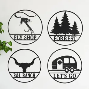 Four circular signs with designs for \“Fly Shop\“ (fly fishing hook), \“Forrest\“ (trees), \“R&L Ranch\“ (bull head), and \“Let's Go\“ (camper trailer).