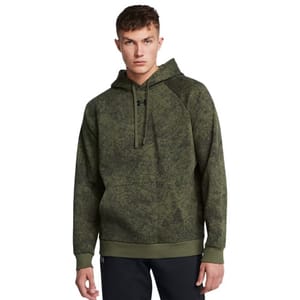 A man wears an olive green Under Armour hoodie with a subtle camouflage pattern and black pants.