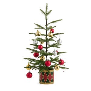 A small artificial Christmas tree decorated with red, gold, and silver baubles, set in a drum-shaped pot with a red and green diamond pattern.