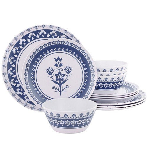 A blue and white dinnerware set featuring plates and bowls with floral and geometric patterns.