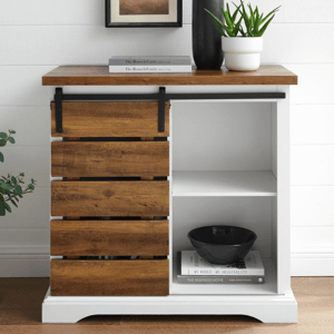 A small sideboard with a wooden top and sliding barn-style door, featuring one shelf. Decor includes a black vase, a potted plant, books, and a black bowl.