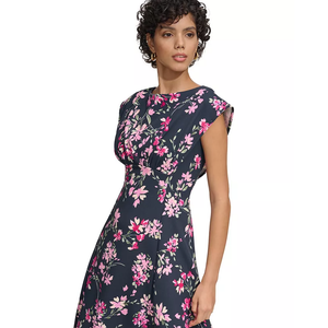 The Calvin Klein Shirred-Waist Dress features a navy base with an all-over pink floral print. It has a fitted silhouette with cap sleeves and a shirred waist for a flattering shape.
