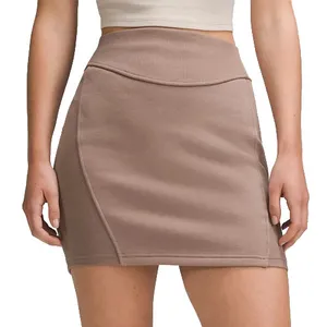 A high-waisted, taupe mini skirt with subtle seam detailing, paired with a cropped white top.