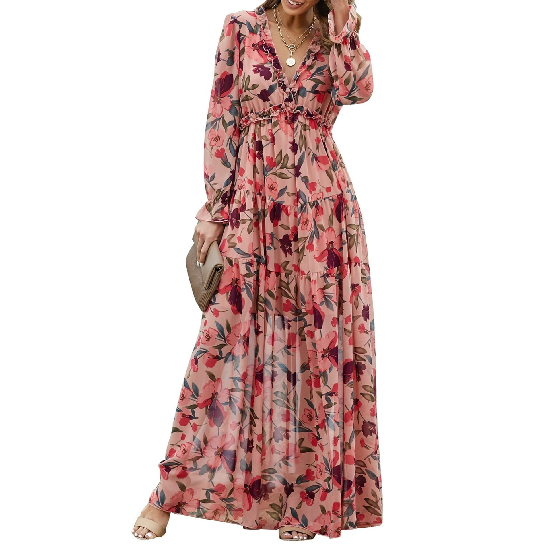 Floral Ruffled Maxi Dress with a pink base and vibrant floral print, featuring a deep V-neckline, long sleeves, ruffled details, and a tiered skirt. Paired with a beige clutch and nude open-toe sandals.