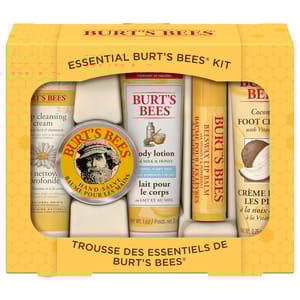 Burt's Bees Essential Kit includes deep cleansing cream, hand salve, body lotion with milk & honey, beeswax lip balm, and coconut foot cream, packaged in a yellow box.