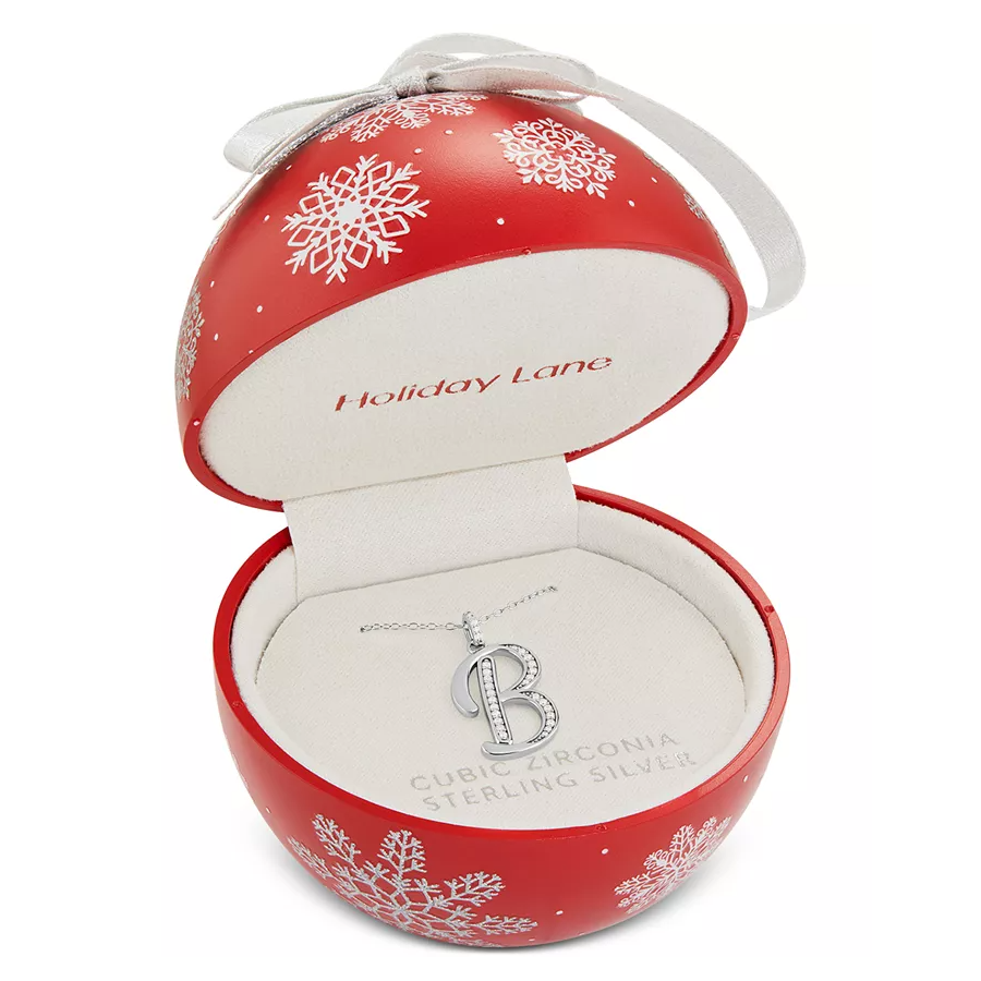 Red ornament-shaped box with snowflakes, containing a shiny silver letter \“B\“ pendant. Made of cubic zirconia and sterling silver, labeled \“Holiday Lane.\“