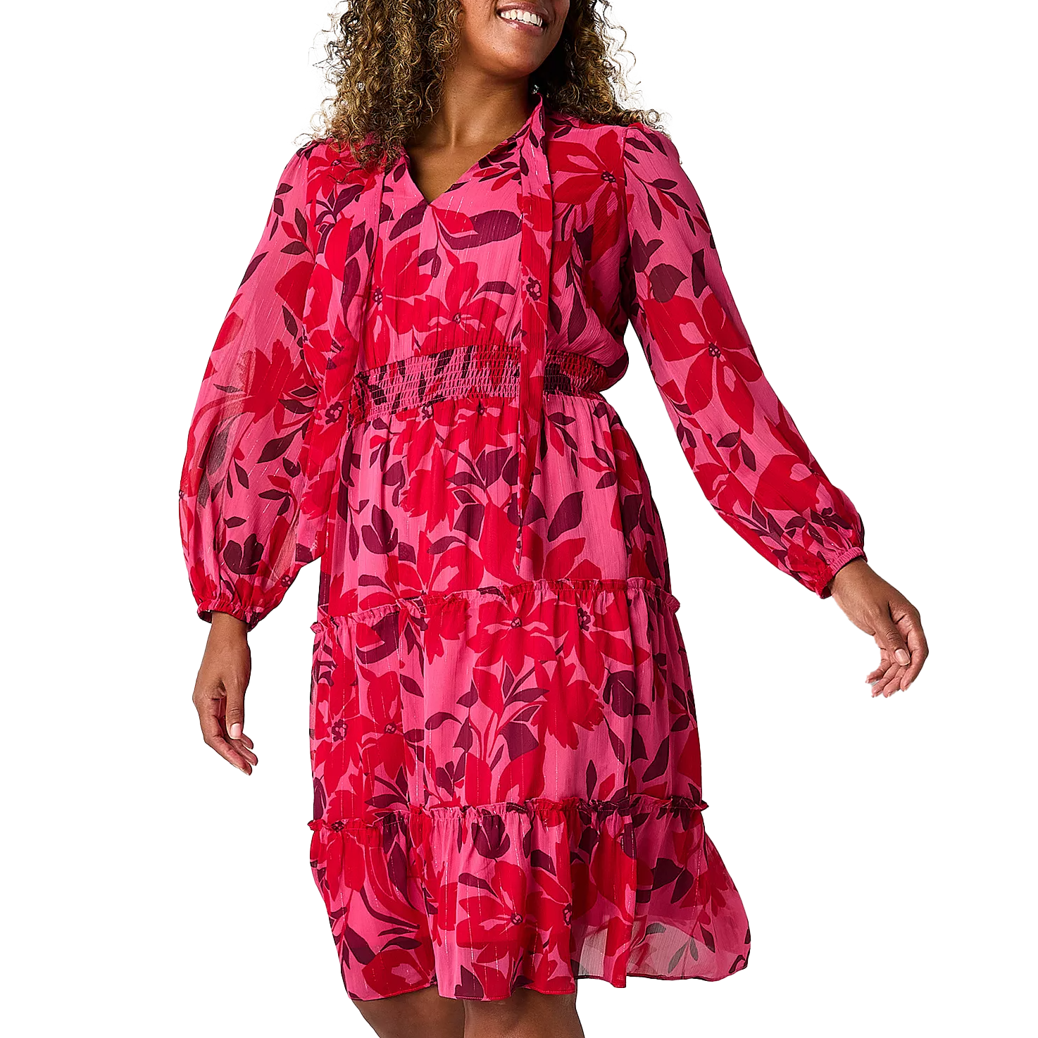 A floral blouson dress with vibrant pink and red patterns, featuring long sleeves, a V-neckline, and an elastic waist. The dress has a tiered skirt for a flowing, feminine look.