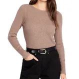 A beige ribbed long-sleeve sweater paired with black high-waisted pants and a black belt with a gold buckle.