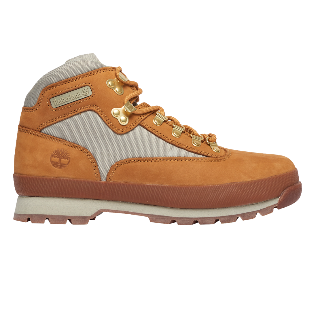A tan and beige Timberland hiking boot with gold eyelets and a rubber sole, featuring the brand's logo on the side.