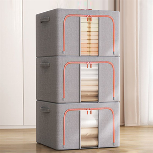 Stacked gray fabric storage drawers with red trim, showcasing towels and bed linens.