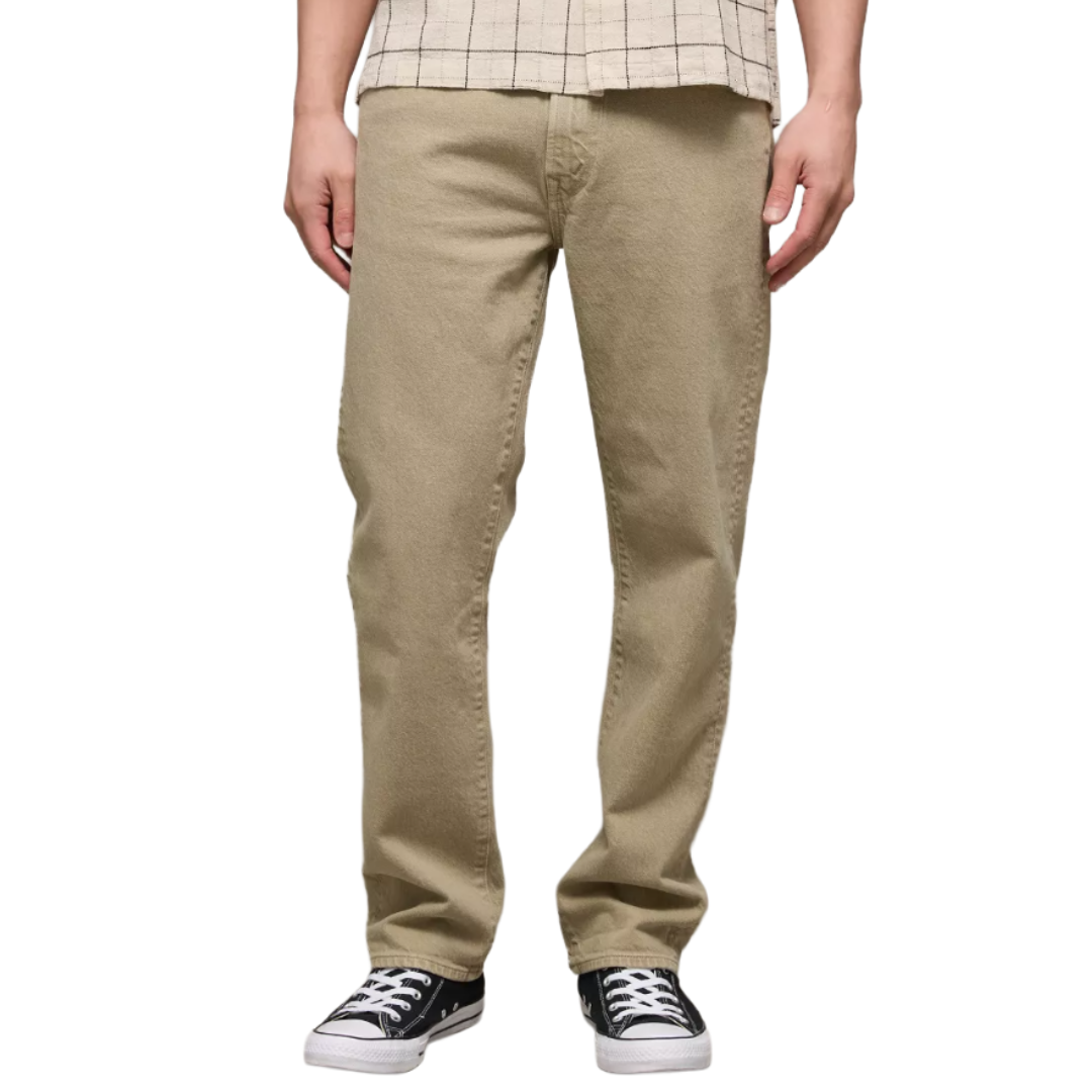 A pair of beige straight-cut pants paired with black and white sneakers and a beige checkered shirt.
