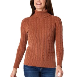 A woman is wearing a brown cable knit turtleneck sweater with long sleeves and ribbed cuffs.