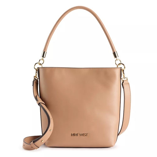 A beige Nine West bucket bag features a smooth leather finish, shoulder strap with gold-tone hardware, and an adjustable crossbody strap.
