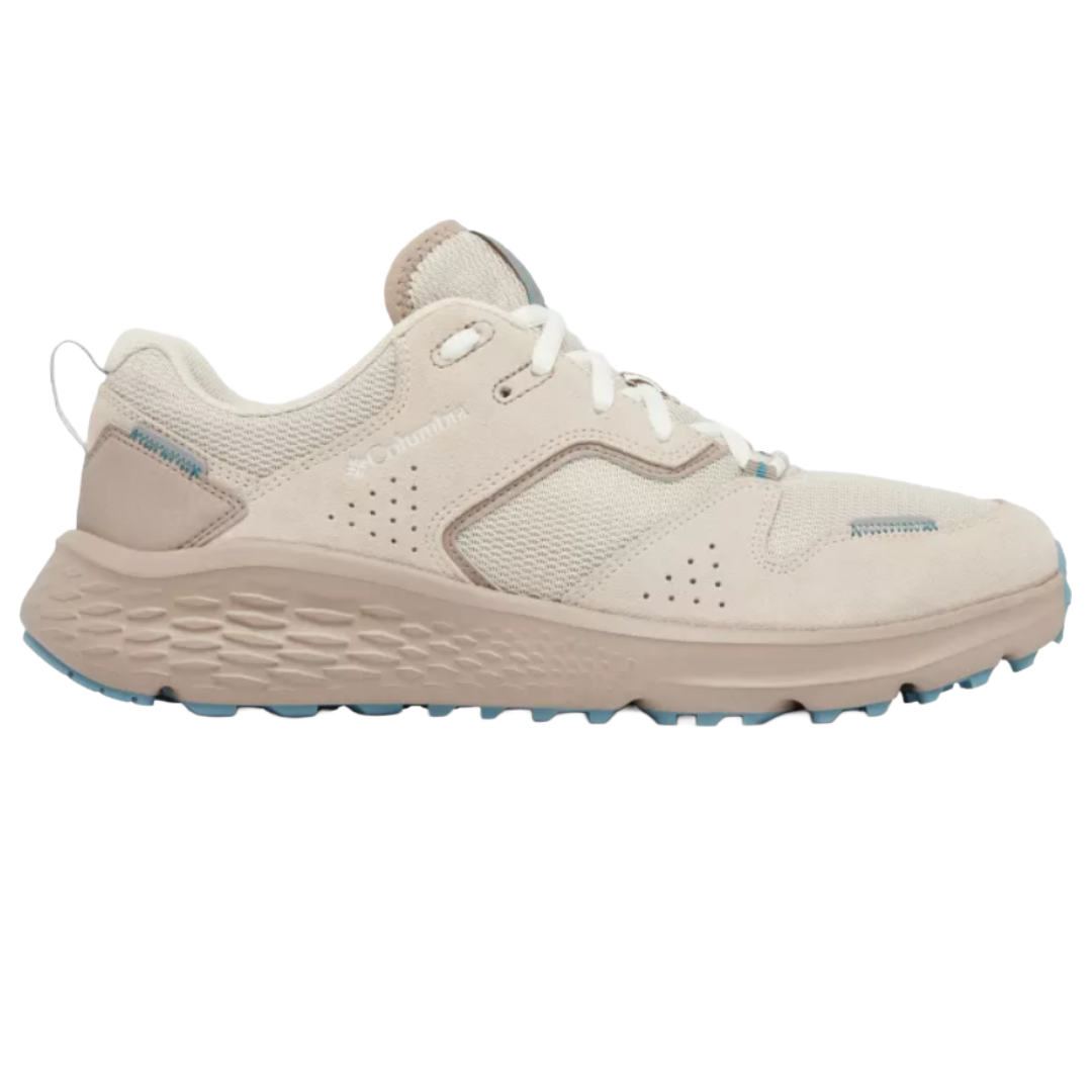 Light beige athletic shoe with a textured sole, perforated detailing, and white laces, featuring blue accents on the sole and stitching. Brand name is visible on the side.