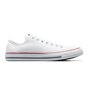 A classic low-top white canvas sneaker with white laces, featuring red and blue stripes on the rubber sole.