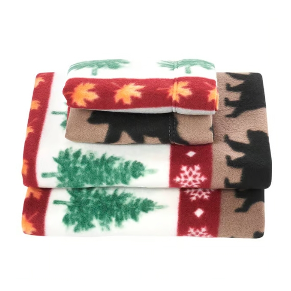 A set of fleece bedsheets with a forest-themed design featuring trees, bears, snowflakes, and autumn leaves in green, red, and brown colors.