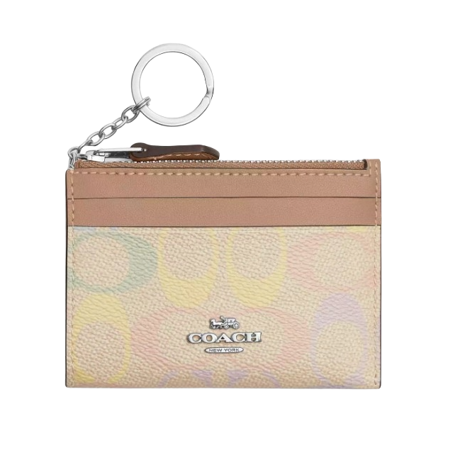 A Coach card holder with a keychain, featuring a multicolored pastel pattern and a front logo. It includes a zippered pocket and card slots.