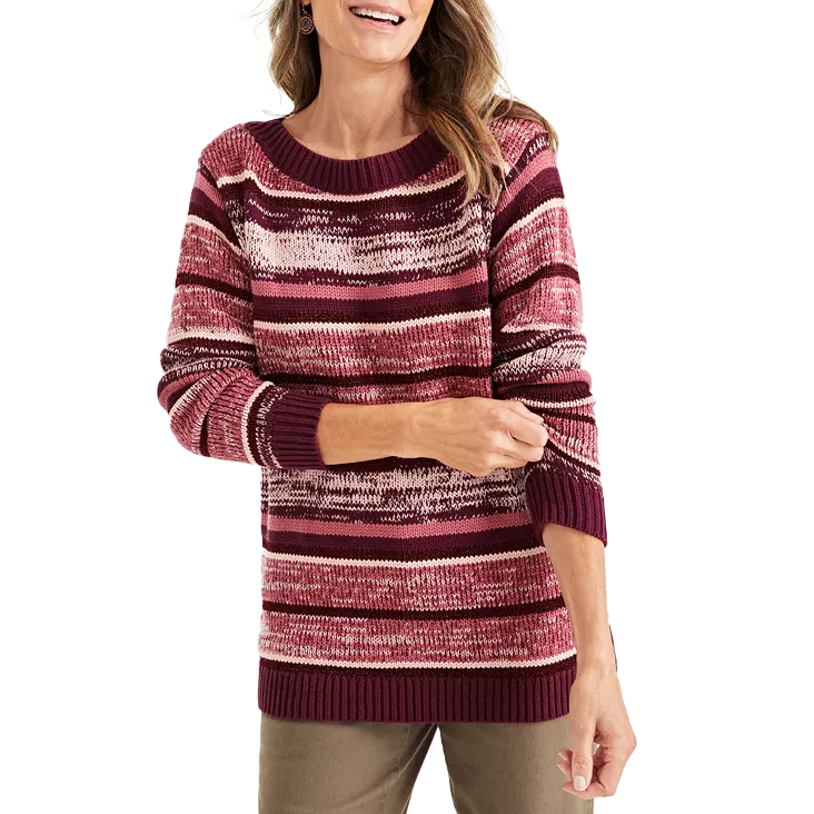 A woman is wearing a maroon and pink striped knit sweater with a round neck and long sleeves, paired with khaki pants.