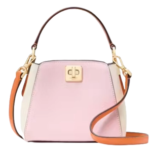 Kate Spade Mini Top Handle Crossbody in pink and white features a structured design with gold-tone hardware, a twist-lock closure, and an adjustable brown strap.