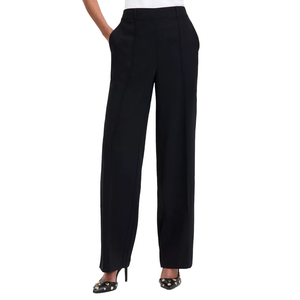 Black wide-leg pants with a front seam detail, paired with black high-heeled shoes adorned with gold embellishments, and a white top tucked in.