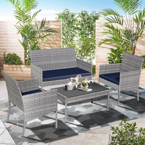 Patio furniture set with a sofa, two chairs, and a coffee table, all with gray wicker design and navy cushions.