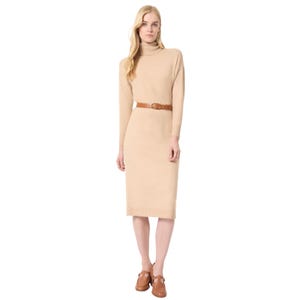 Beige knee-length sweater dress with long sleeves, a turtleneck, and a brown belt at the waist. Paired with tan loafers.