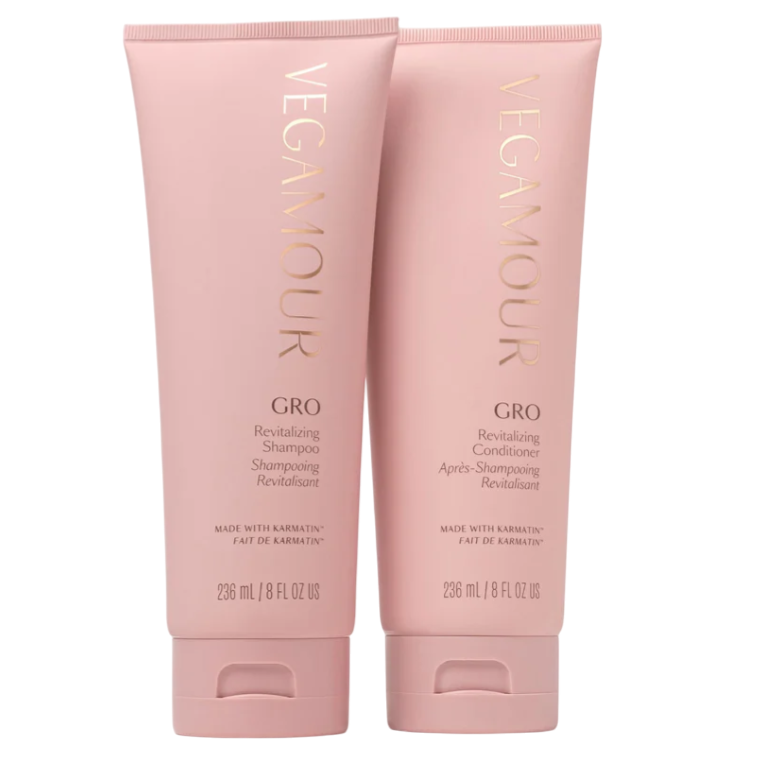 Two pink bottles labeled \“VEGAMOUR\“ containing GRO Revitalizing Shampoo and Conditioner, each 236 mL (8 fl oz US), made with Karmatin.