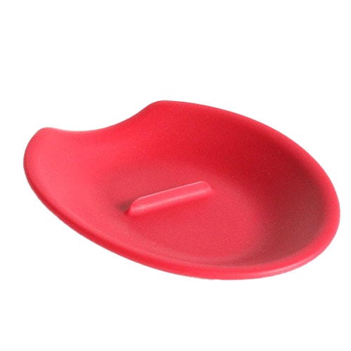 A red spoon rest with a ridge in the middle for cracking eggs.