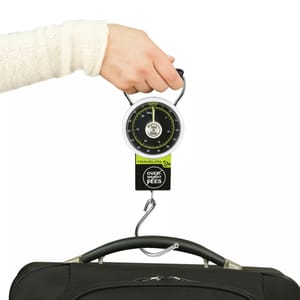 A hand-held luggage scale with a dial displays weight, featuring a hook for baggage attachment. The device warns against overweight fees.
