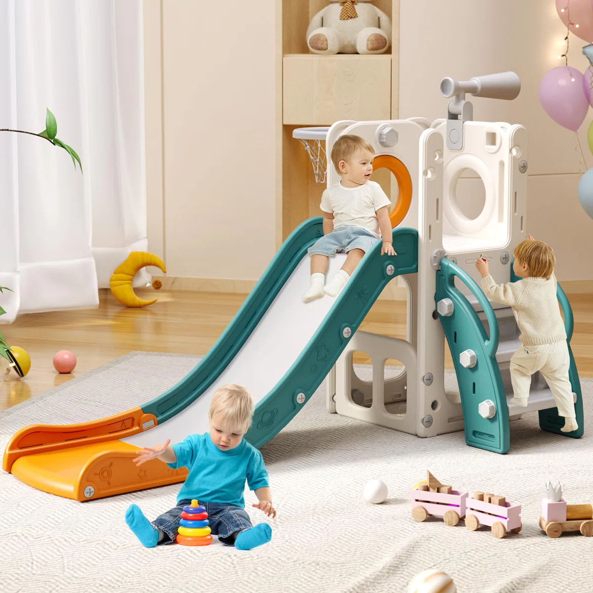 Children's indoor playset with a slide, climbing features, and a telescope attached. Two children are playing on the structure, while one child sits on the floor playing with a stacking toy. Additional toys, including a wooden train, are scattered on the rug.