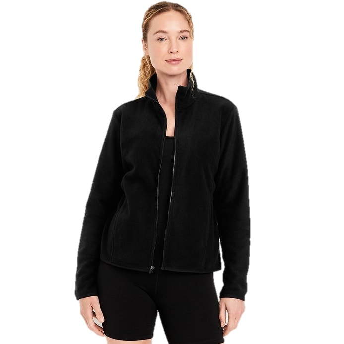 A woman wears a black zip-up fleece jacket with long sleeves and a high collar, paired with black shorts.